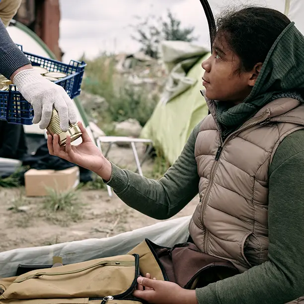 A woman recieving food from an aid worker